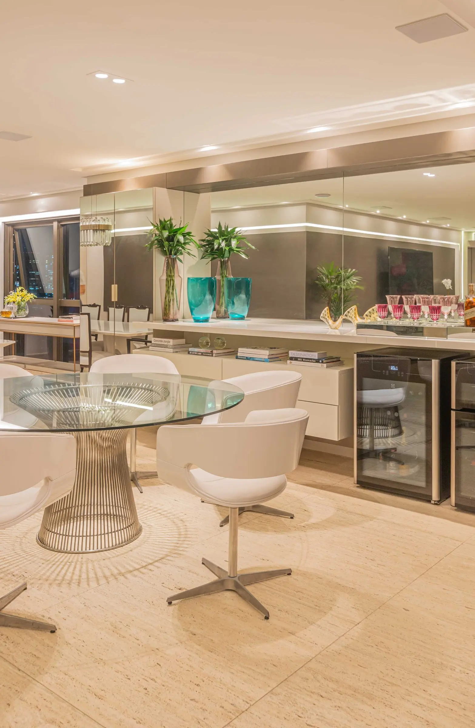 Glass table with white chairs and the bar behind