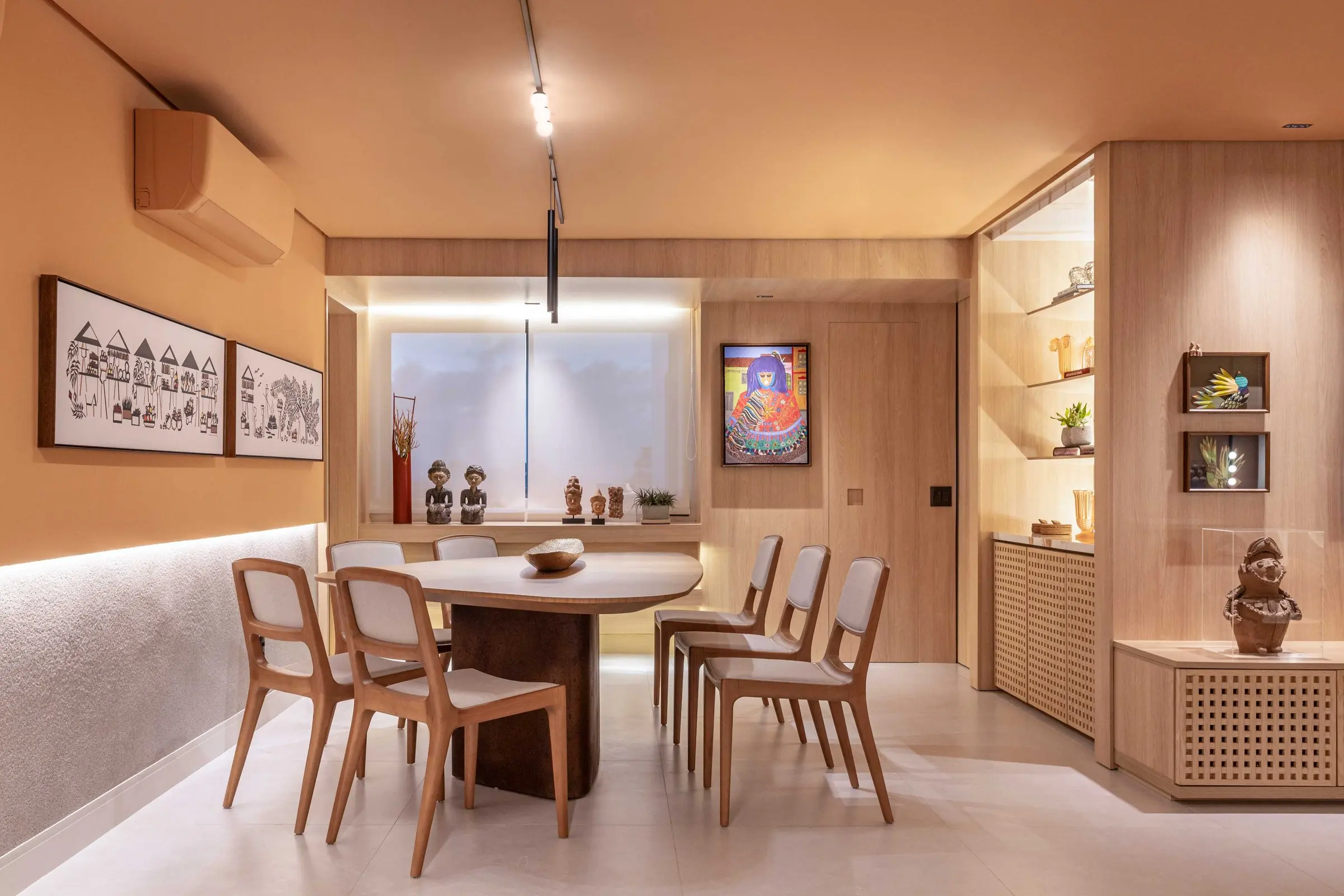 Dining room with wooden chairs and framed artworks