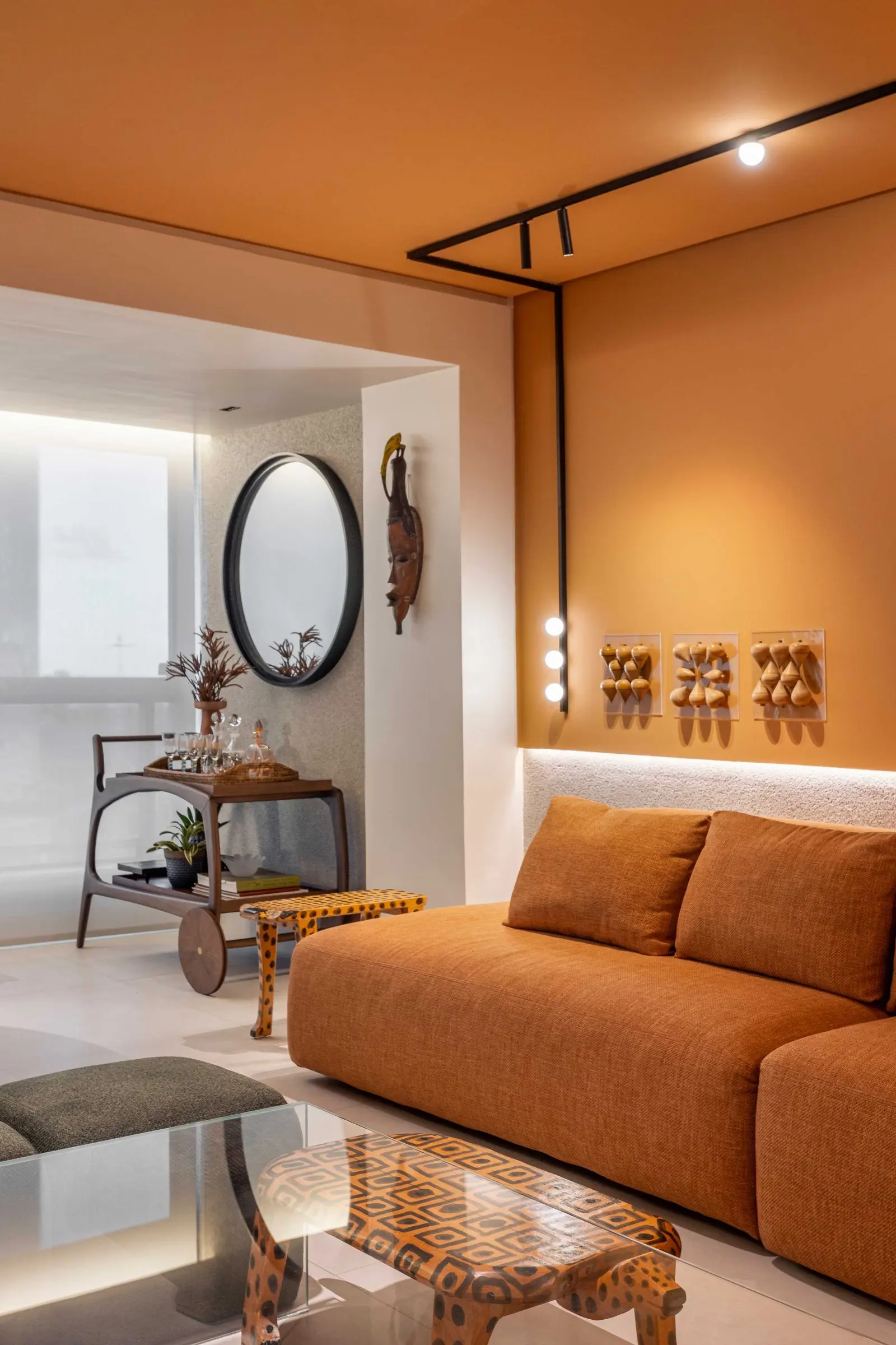 Living corner with a round mirror and a bar cart