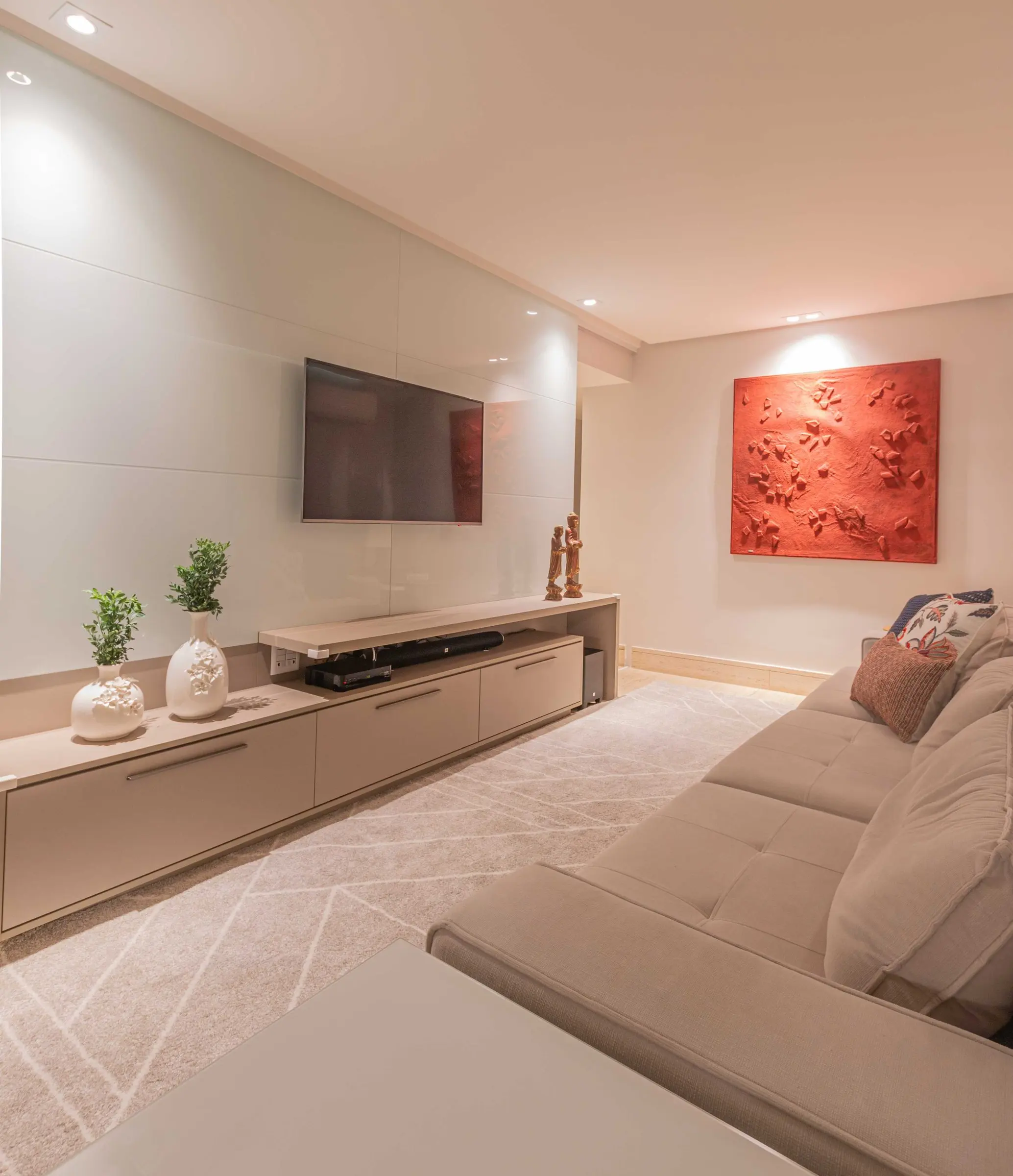 TV room with a grey sofa and a red relief artwork